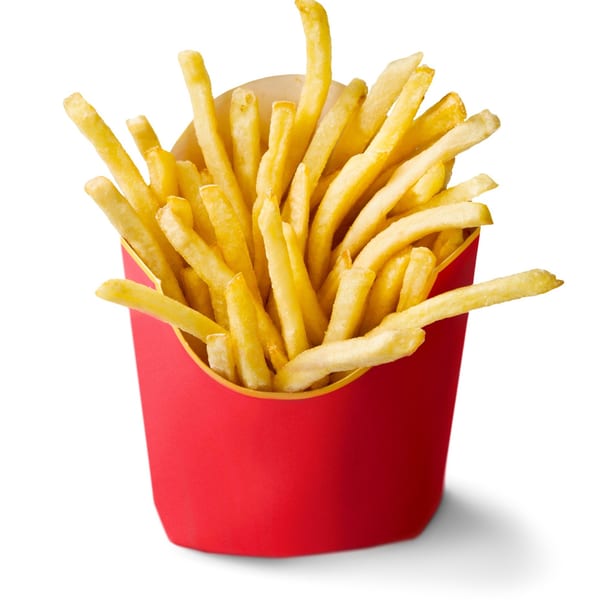 Golden french fries in a red paper container, isolated on a white background.